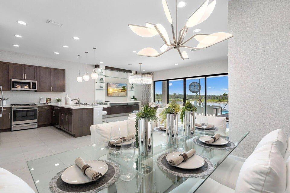 new homes in naples, fl. A stunning kitchen with a view and eating area with glass table.