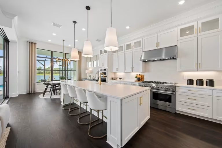 new homes in naples, fl. A white kitchen with an island and four chairs.