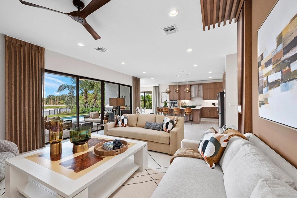 new homes in naples, fl. A gorgeous living room with a kitchen in the background. 