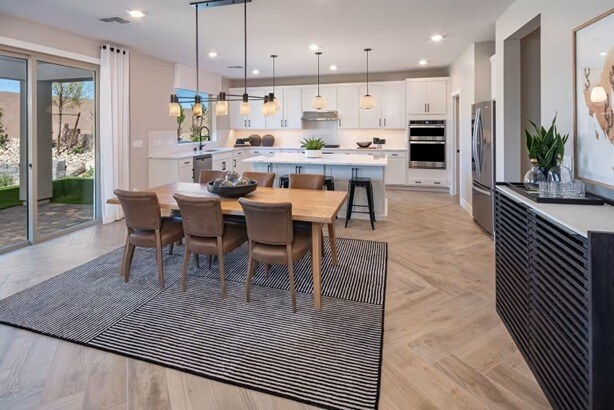 new homes in Las Vegas. A dining room with a kitchen in the background. KITCHELL-Las-Vegas