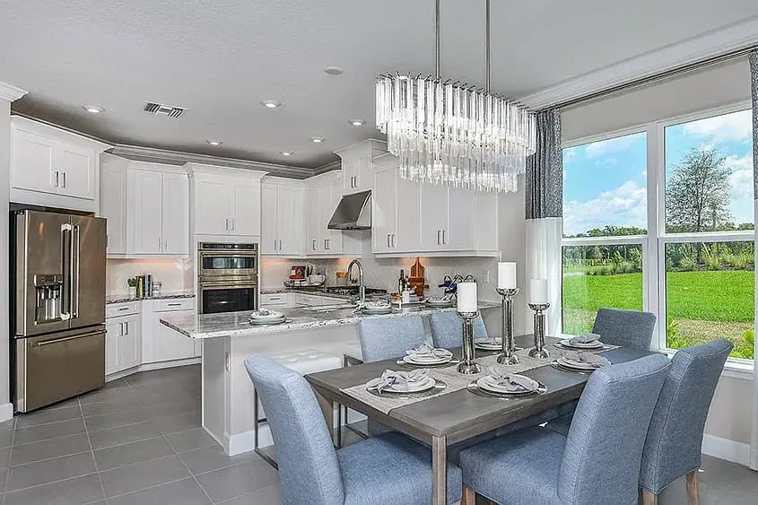 new home developments in sarasota, fl. A high-end kitchen and living room with a fancy chandelier. 