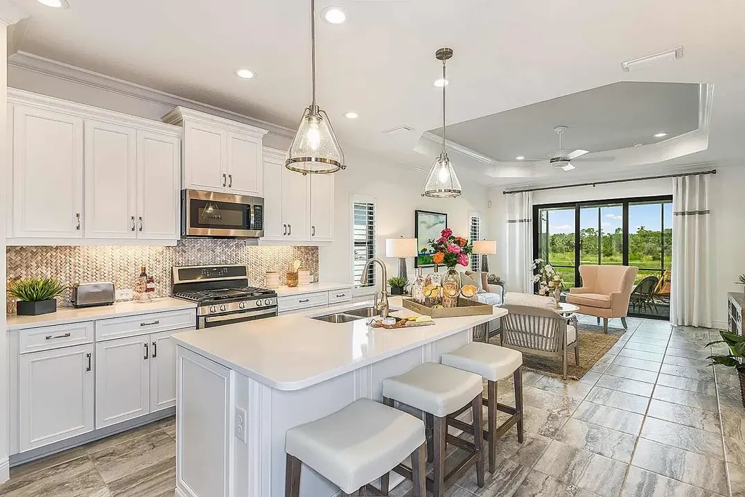 new home developments in sarasota, fl. A well-lit, open kitchen and dining room with large windows that look out to the backyard.