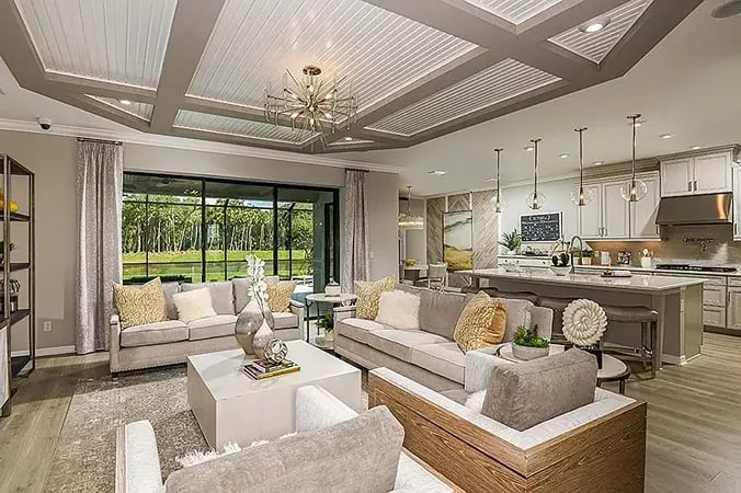 new home developments in sarasota, fl. A beautiful living room and kitchen that's fully furnished and with modern light fixtures.