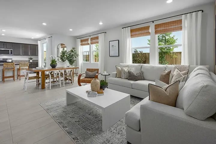 new homes in Antioch, CA. View from a living room with a white couch and kitchen. PLAN 1675-Antioch, CA