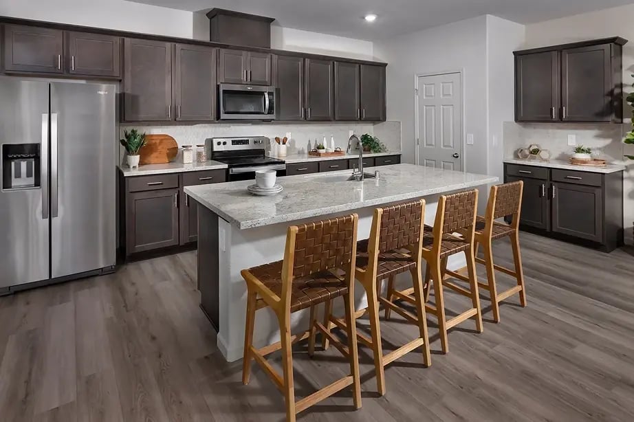 new homes in Antioch, CA. A kitchen with an island and wooden chairs. RESIDENCE 1-Antioch, CA