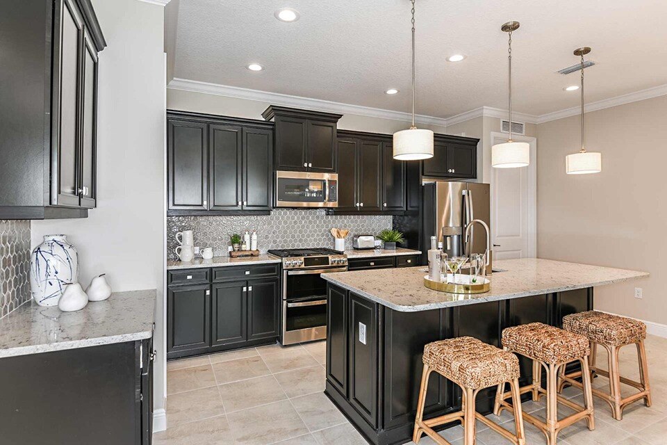 new homes in naples, fl. A kitchen with marble top island and stools. 