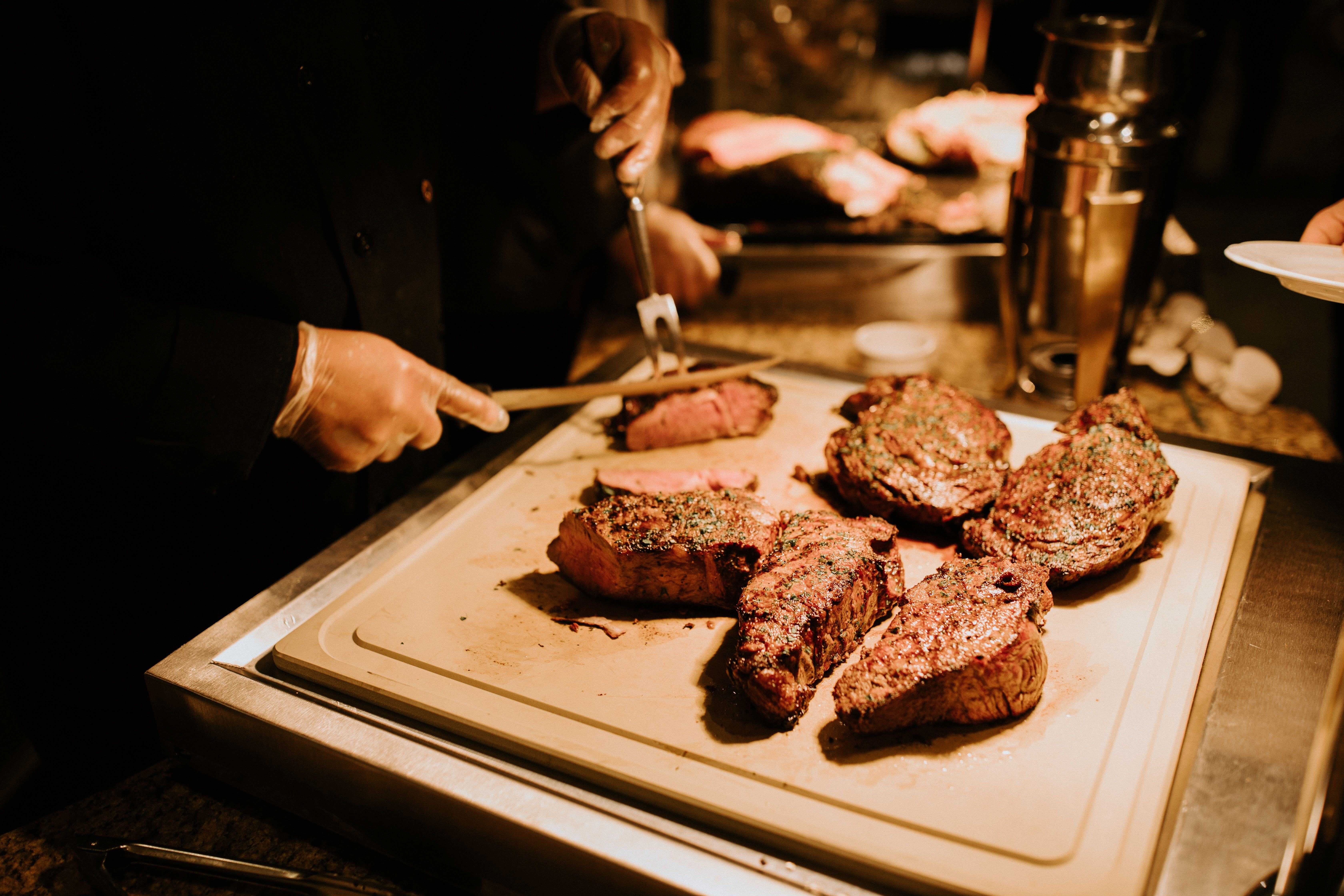 Fun things to do in Port St. Lucie. A server carves steak on a cutting board in a steakhouse.