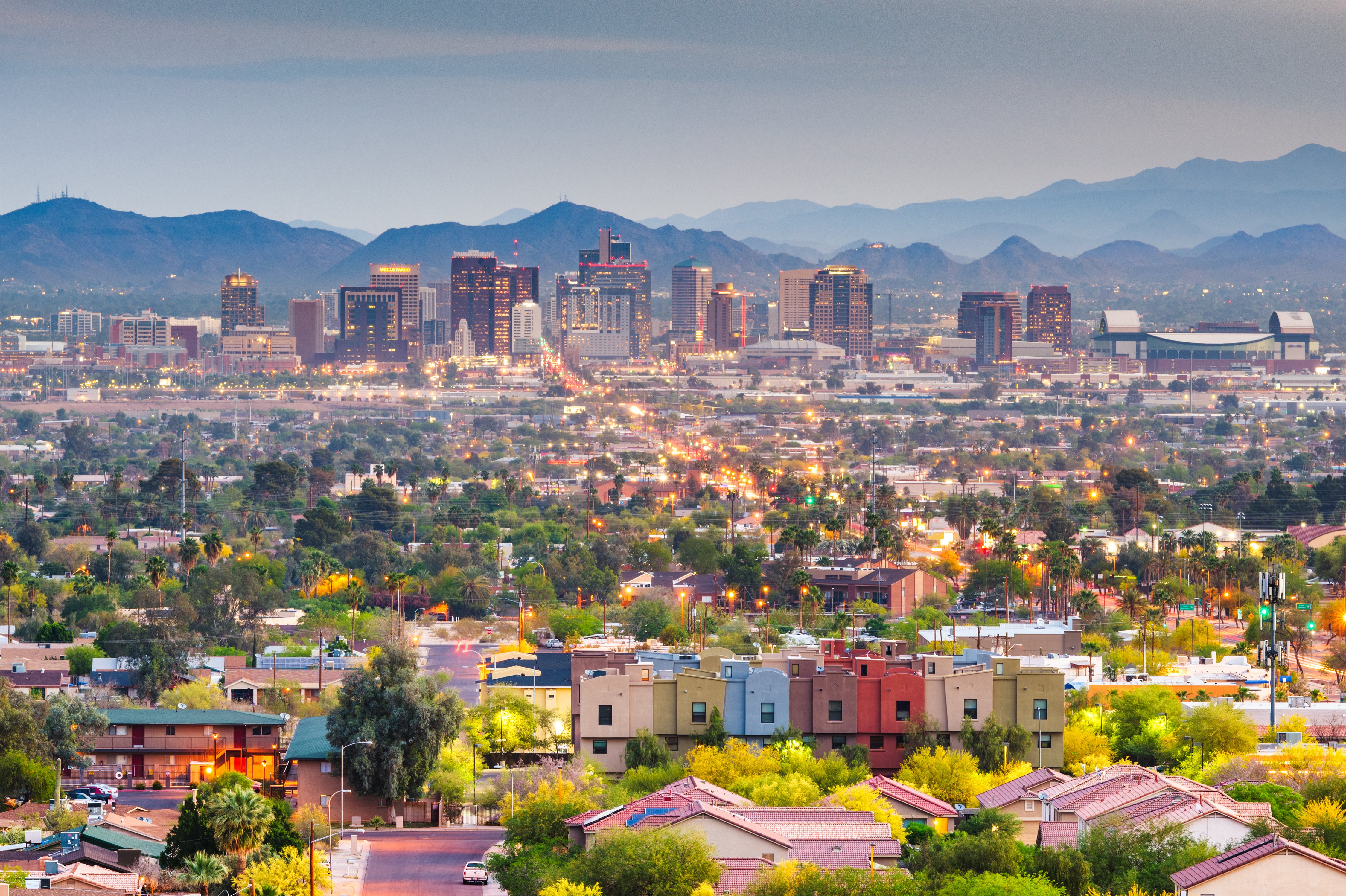 Is phoenix affordable? City view of Phoenix with colorful houses in front and mountains in the background.